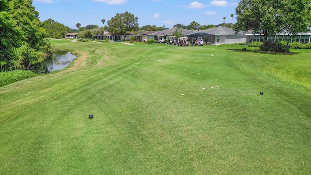 surrounding community with a water view and a lawn