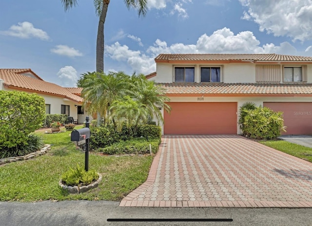 mediterranean / spanish house featuring a garage and a front yard