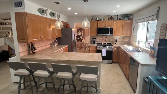 kitchen featuring sink, backsplash, stainless steel appliances, and kitchen peninsula