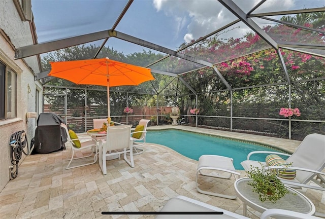 view of swimming pool with glass enclosure and a patio area