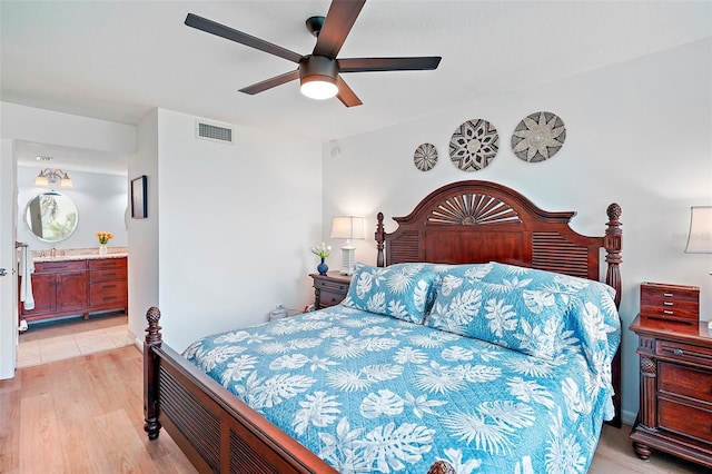 bedroom featuring light hardwood / wood-style floors, ceiling fan, and ensuite bathroom