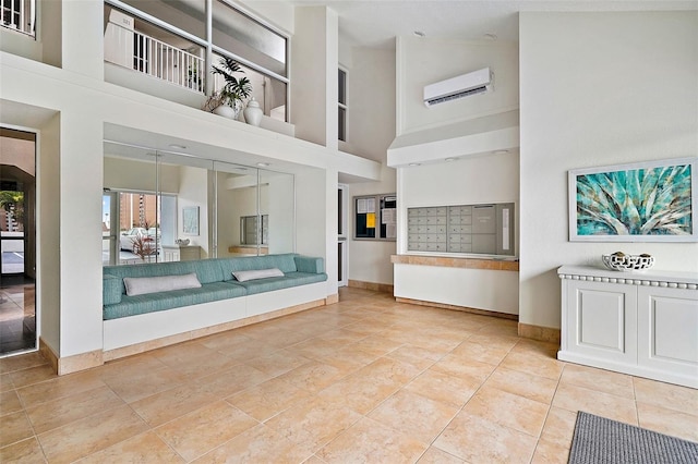 unfurnished living room featuring a wall mounted air conditioner, a towering ceiling, mail boxes, and tile patterned floors