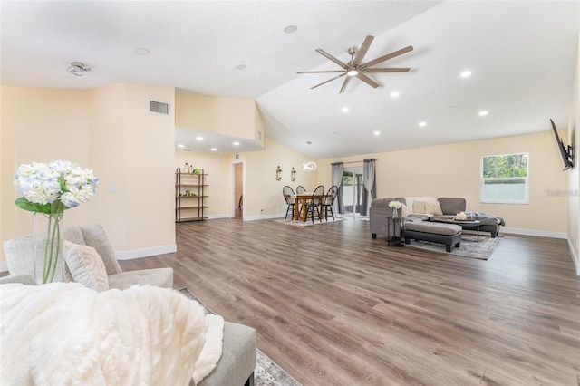 living room with hardwood / wood-style floors and high vaulted ceiling