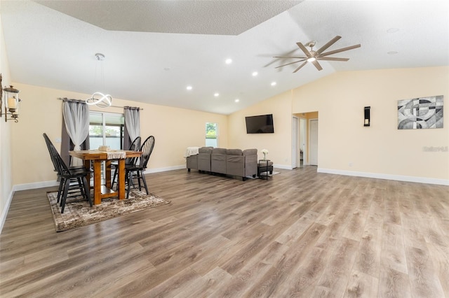 dining area featuring ceiling fan, vaulted ceiling, and light wood-type flooring