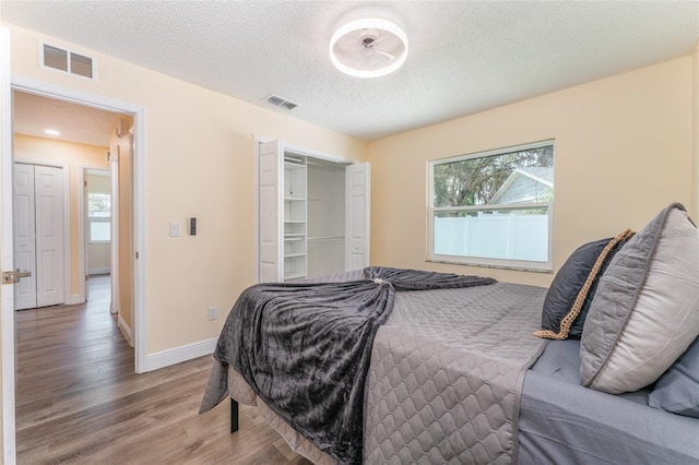 bedroom featuring hardwood / wood-style floors, a textured ceiling, and a closet