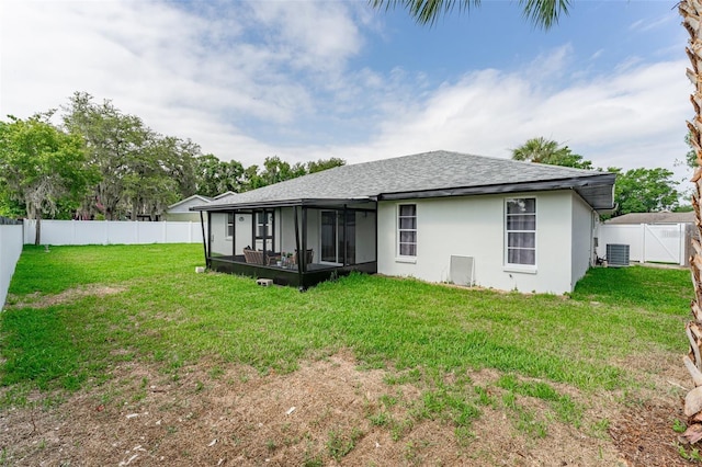 rear view of house featuring a yard, a sunroom, and central air condition unit