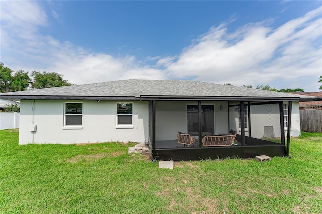 back of property with a yard and a sunroom