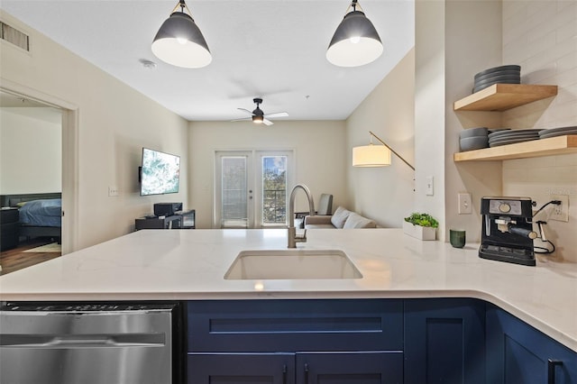 kitchen with pendant lighting, blue cabinetry, light stone countertops, and sink