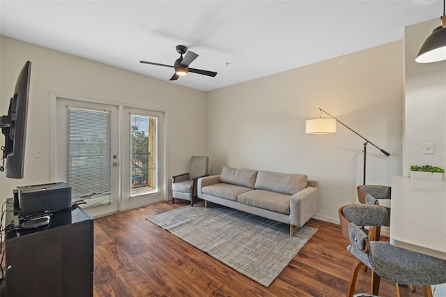 living room featuring dark wood-type flooring and ceiling fan