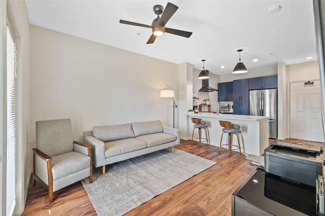 living room featuring ceiling fan and light hardwood / wood-style floors