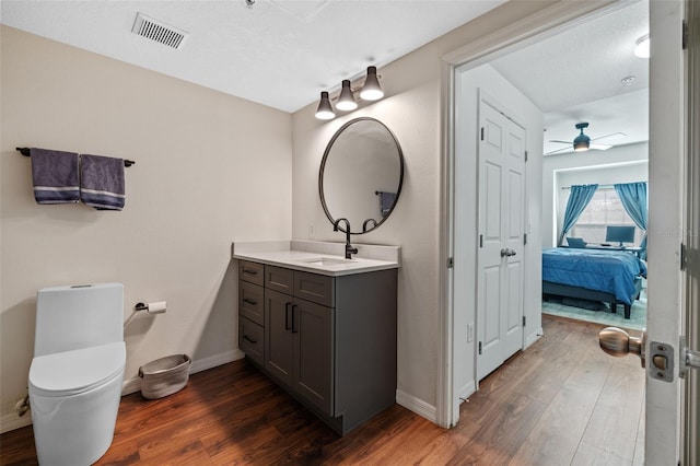 bathroom with ceiling fan, wood-type flooring, toilet, and vanity