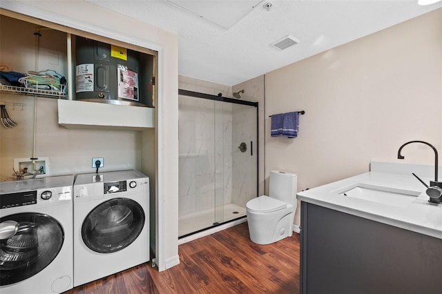 laundry area featuring sink, dark wood-type flooring, and washer and dryer