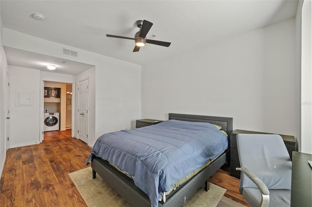 bedroom with dark wood-type flooring, ceiling fan, and washer / clothes dryer