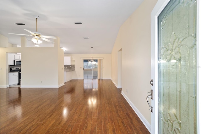 entryway featuring lofted ceiling, dark hardwood / wood-style floors, and ceiling fan with notable chandelier