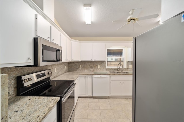 kitchen with appliances with stainless steel finishes, sink, white cabinets, and backsplash