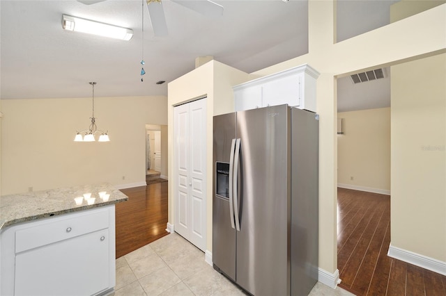 kitchen with white cabinetry, stainless steel refrigerator with ice dispenser, and light hardwood / wood-style flooring