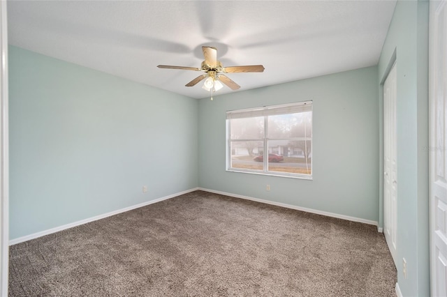 carpeted spare room featuring ceiling fan