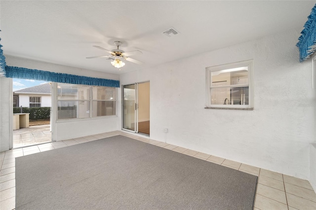 tiled empty room featuring ceiling fan