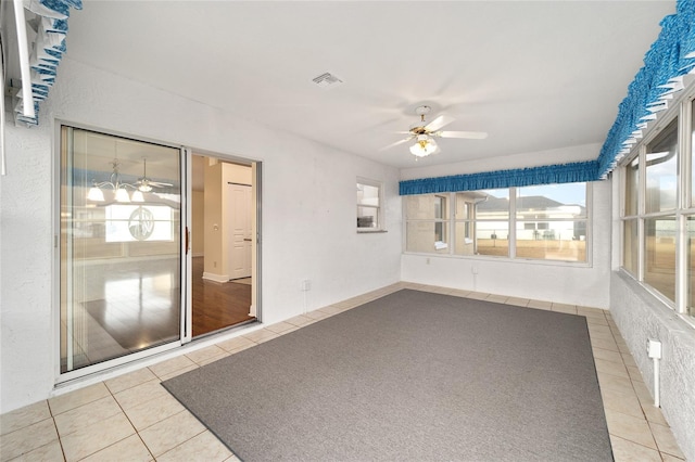 unfurnished sunroom with ceiling fan