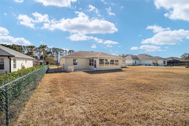 rear view of house with a lawn and a patio