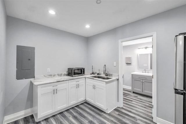 kitchen with stainless steel appliances, sink, white cabinets, and electric panel