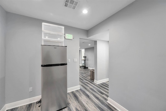 corridor with hardwood / wood-style flooring