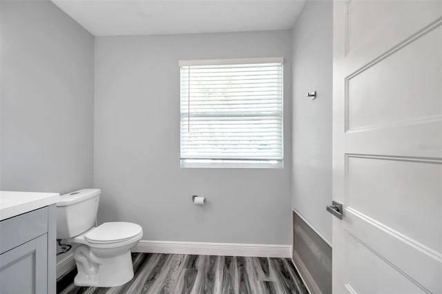 bathroom featuring vanity, hardwood / wood-style floors, plenty of natural light, and toilet