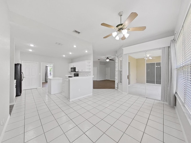 kitchen with white cabinetry, black appliances, a center island, and light tile patterned flooring