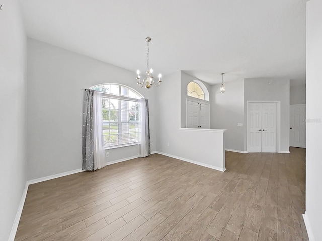 spare room featuring hardwood / wood-style flooring and a notable chandelier