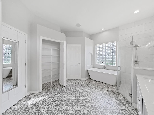 bathroom featuring vanity, a wealth of natural light, and plus walk in shower