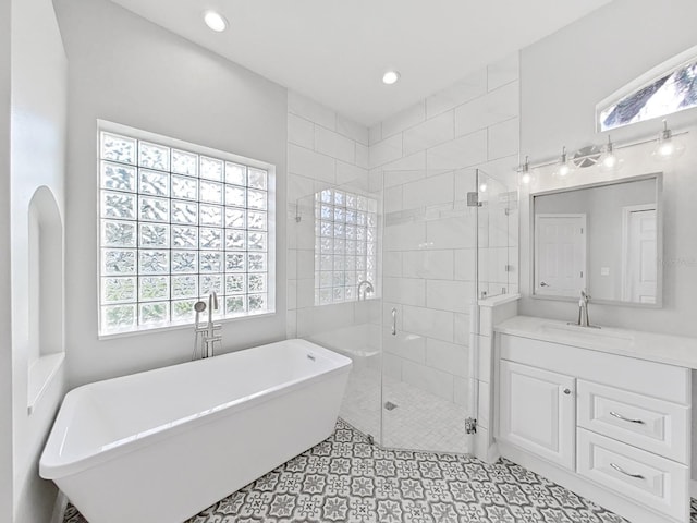 bathroom with vanity and independent shower and bath