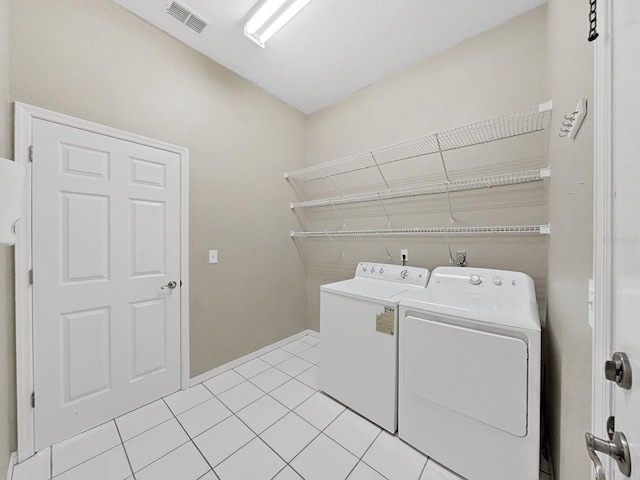 laundry area featuring light tile patterned flooring and washing machine and clothes dryer