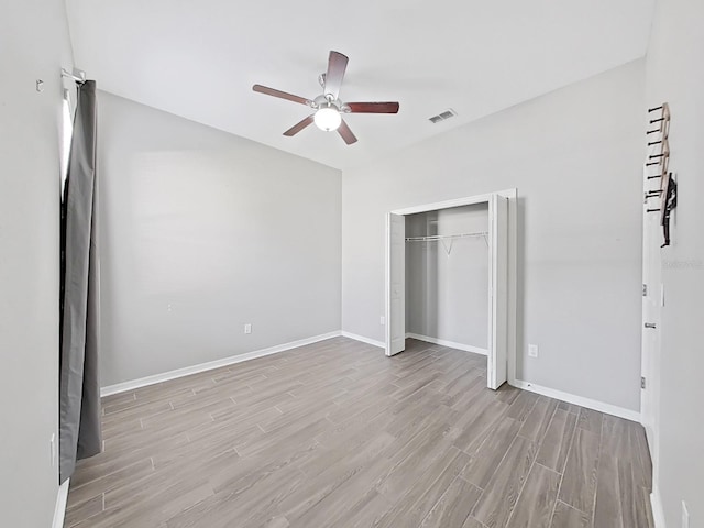 unfurnished bedroom featuring ceiling fan, a closet, and light wood-type flooring