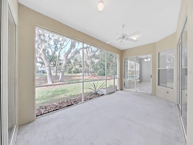 unfurnished sunroom with ceiling fan