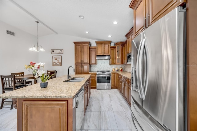 kitchen with sink, vaulted ceiling, a center island with sink, appliances with stainless steel finishes, and pendant lighting