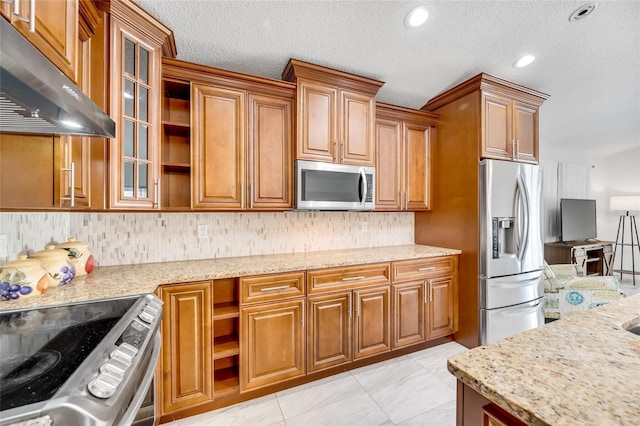 kitchen with backsplash, light tile patterned floors, stainless steel appliances, light stone countertops, and a textured ceiling