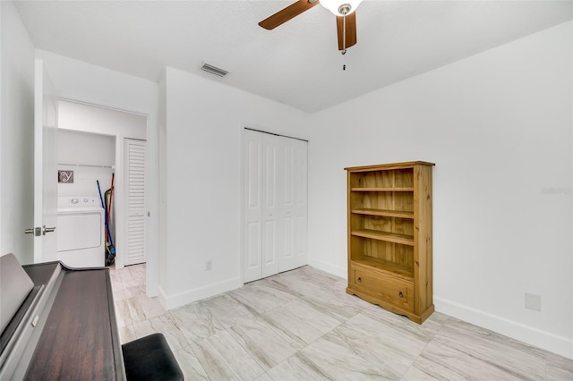 unfurnished bedroom featuring washer / clothes dryer, ceiling fan, and a closet