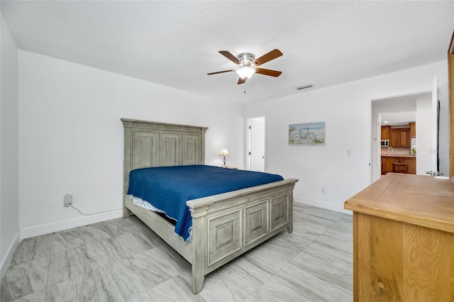 bedroom featuring ceiling fan and a textured ceiling