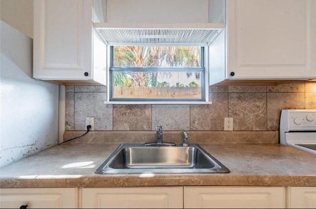 kitchen featuring sink, white electric range, and white cabinets