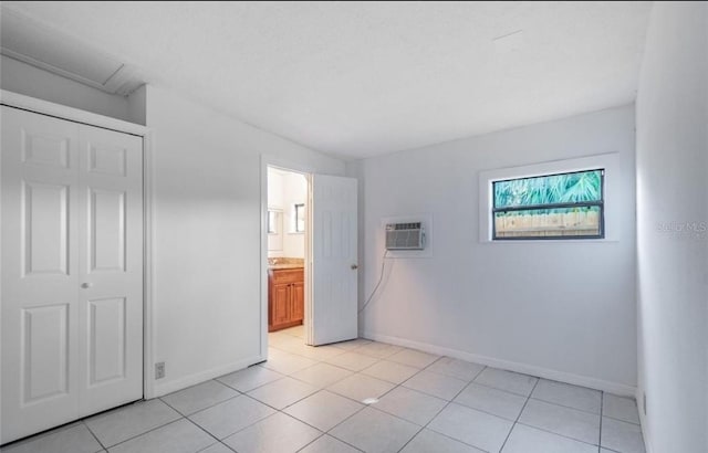 unfurnished bedroom featuring a wall mounted air conditioner and light tile patterned floors