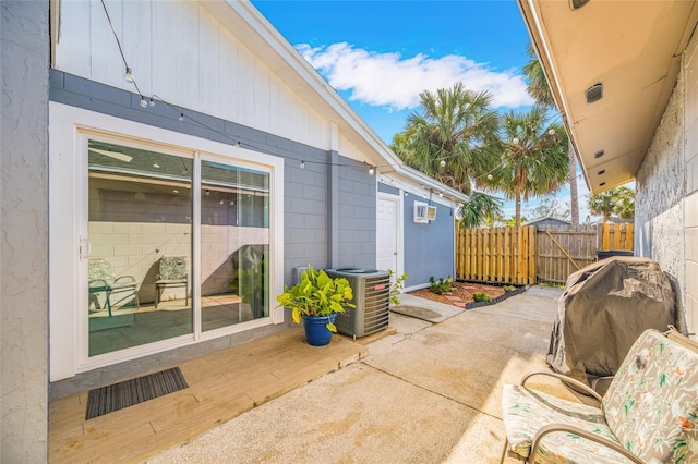 view of patio featuring cooling unit, a grill, and a wall unit AC