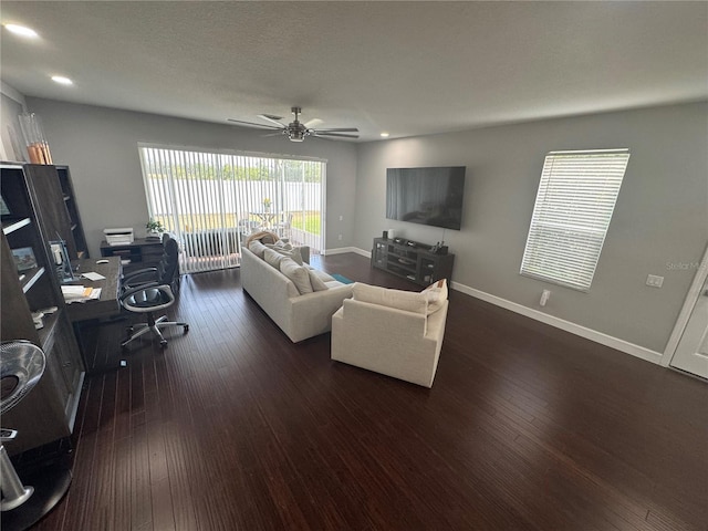 living room with a textured ceiling, dark hardwood / wood-style floors, and ceiling fan