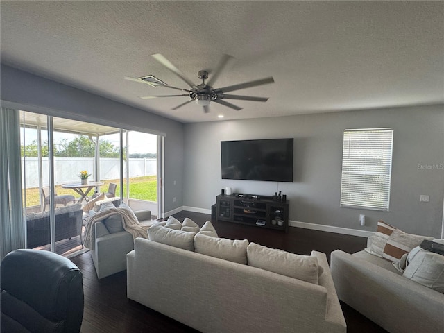 living room with dark hardwood / wood-style flooring, a textured ceiling, and ceiling fan