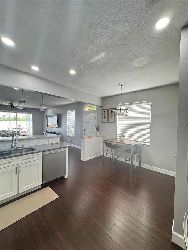 kitchen with sink, white cabinetry, decorative light fixtures, dark hardwood / wood-style floors, and dishwasher