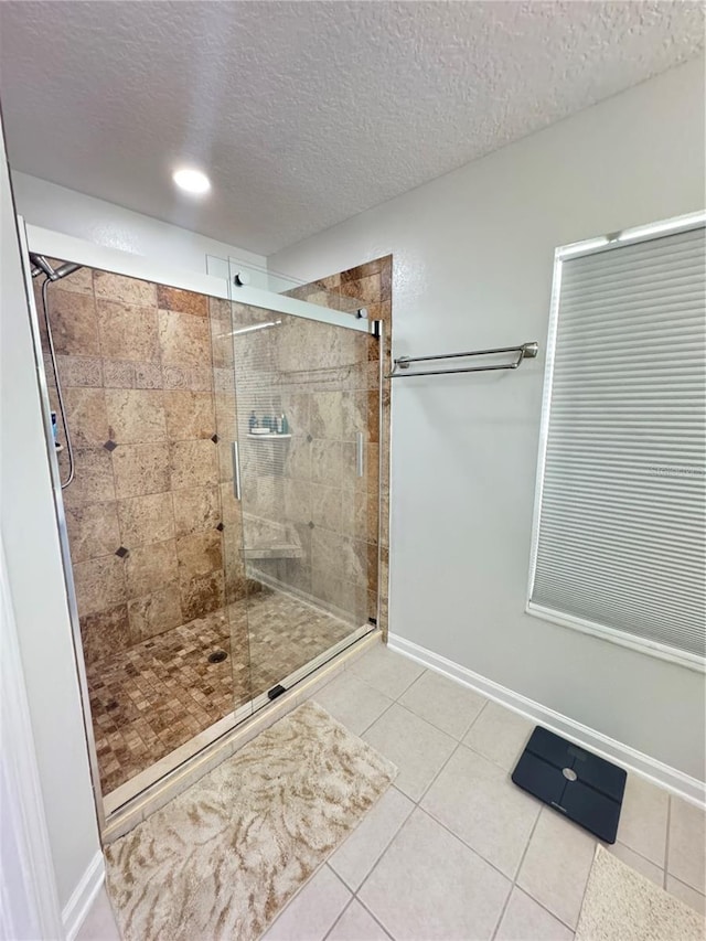 bathroom with walk in shower, tile patterned floors, and a textured ceiling