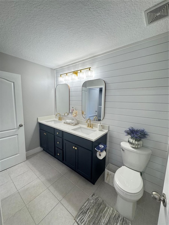 bathroom with vanity, tile patterned floors, toilet, and a textured ceiling