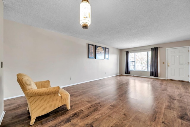 unfurnished room with a textured ceiling and dark hardwood / wood-style flooring