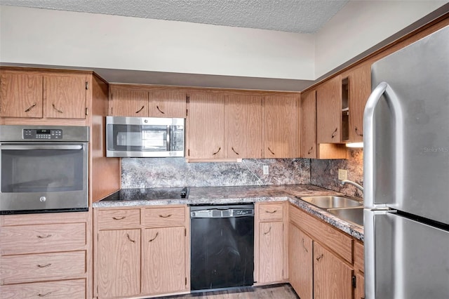 kitchen featuring sink, tasteful backsplash, a textured ceiling, light wood-type flooring, and black appliances