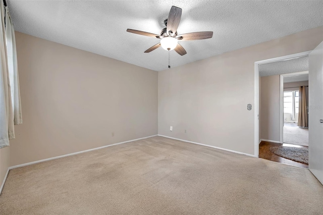 carpeted spare room with ceiling fan and a textured ceiling