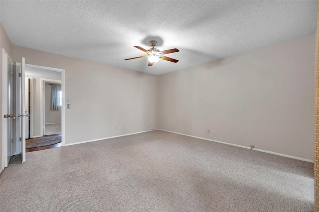 carpeted spare room with a textured ceiling and ceiling fan